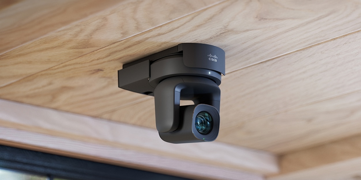 Modern meeting room with a video conferencing screen/camera set up, people on a call.