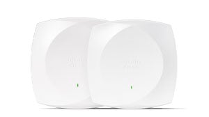 Laptop or tablet screen showing a network management dashboard, with a Meraki access point or switch nearby.