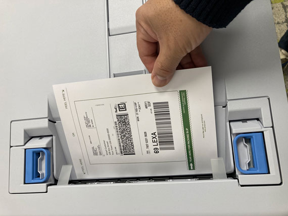 Roll of blank labels beside a printer, or labels being applied to boxes/pallets.